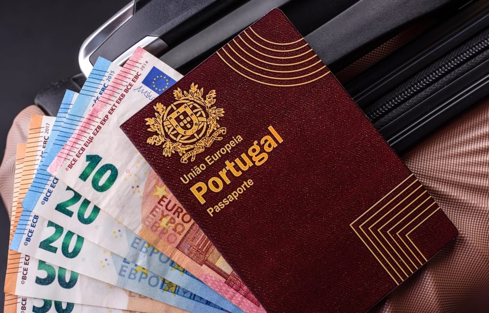 International passport of a citizen of Portugal on a suitcase, departure from the airport, international travel